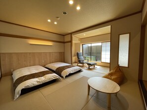 A hotel room with two beds, a small table, and a chair. - Hotel Hisagoso (Shibata)