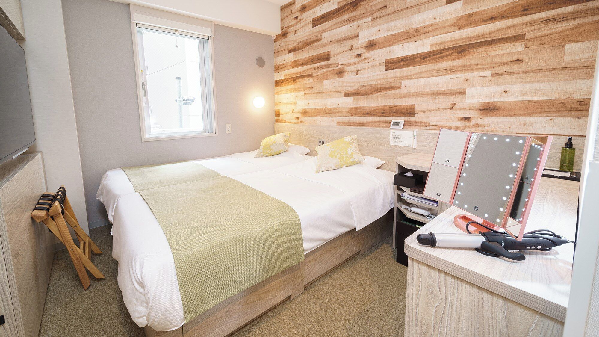 A bedroom with a bed, bedside table, mirror, and wooden wall paneling.