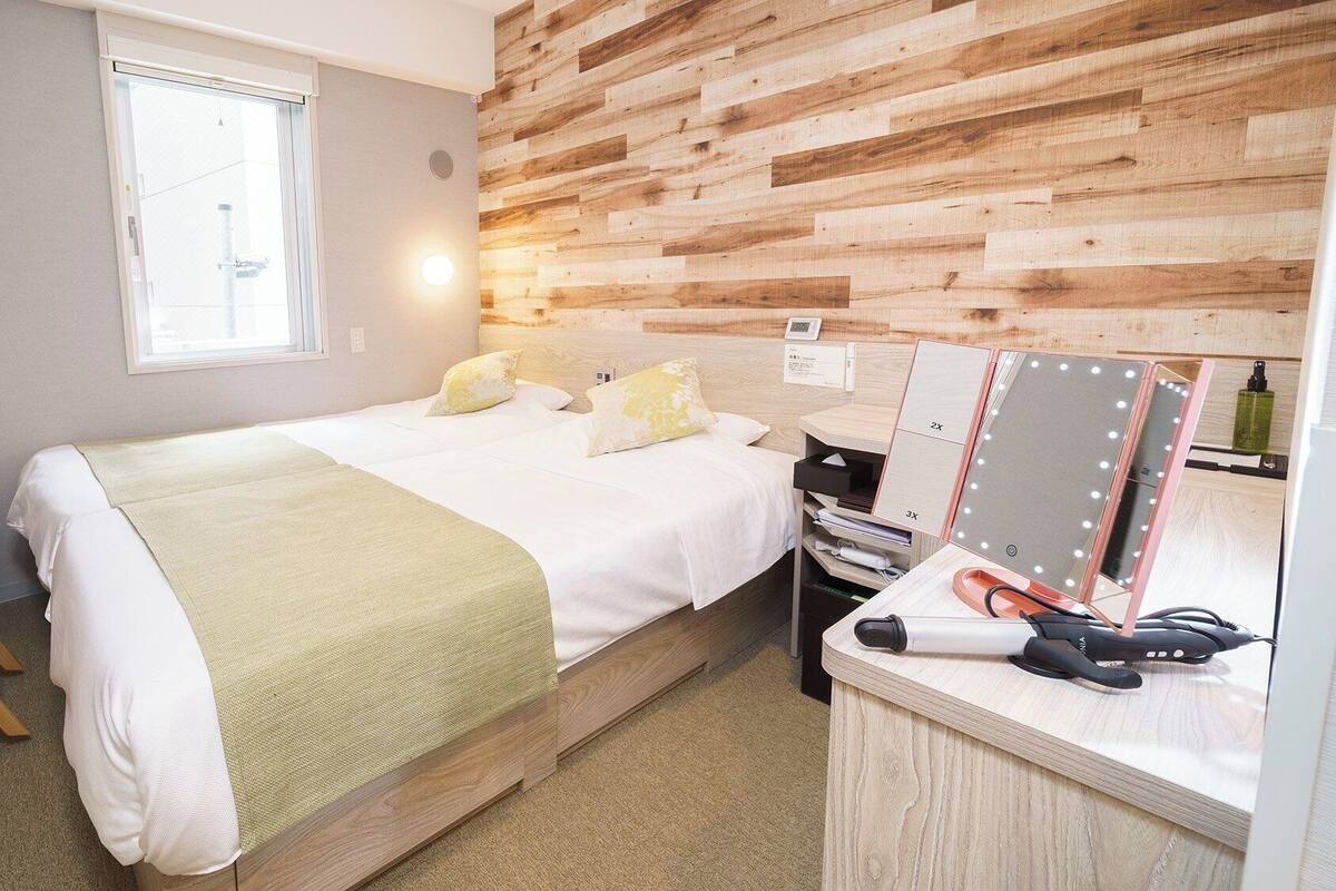 Una camera da letto con un letto, un comodino, uno specchio e rivestimenti in legno a parete.