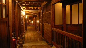 A wooden hallway with a wooden floor, a fire extinguisher, and a wooden railing. - Shinhotaka Onsen Resort In Chirorian (Takayama)