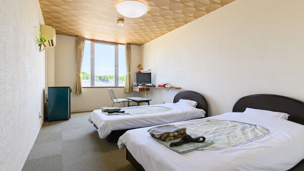 A hotel room with two beds, a desk, a television, and a window with curtains. - Tabist Chunichi Business Hotel Iseshima (Shima)
