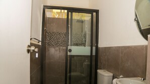 A bathroom with a glass-enclosed shower, a toilet, and a sink. - YAKU eco house (La Banda de Shilcayo)