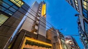 A modern hotel with a prominent 'Super Hotel' sign, a brick facade, and a balcony with greenery.