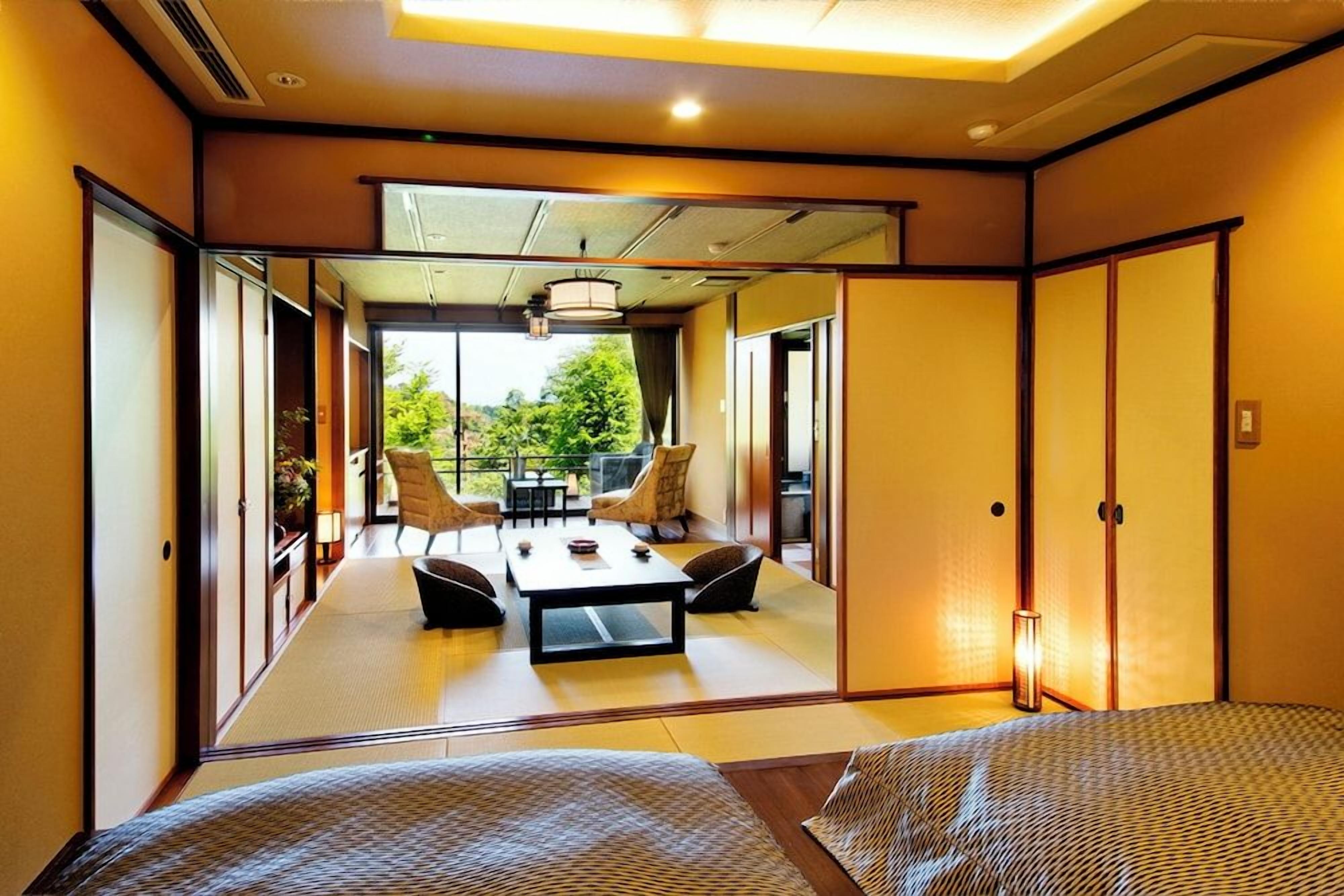 A traditional Japanese-style room with tatami flooring, a low table, and chairs.