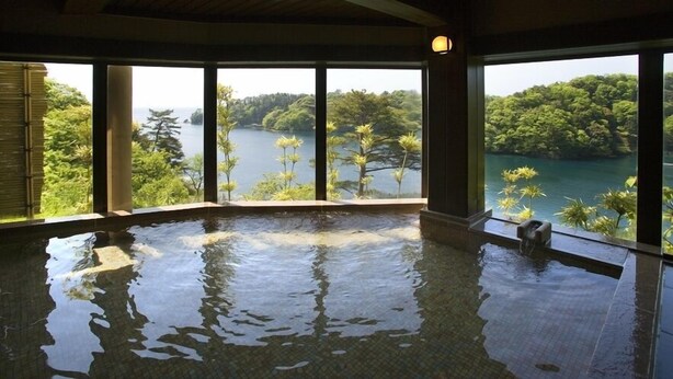 An indoor swimming pool with a view of a lake and forest. - Dokutsuburo no Yado Hyakurakuso (Noto)