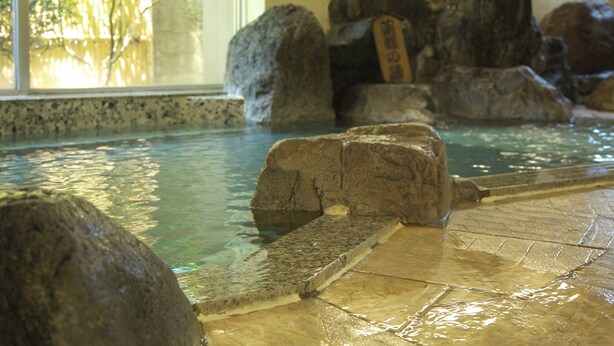 A pool with large rocks and a tiled walkway. - Gero Onsen Kanko Hotel Yumotokan (Gero)