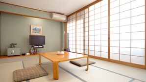 A traditional Japanese room with tatami flooring, a low wooden table, a television, and a sliding shoji screen. - Gero Onsen Kanko Hotel Yumotokan (Gero)