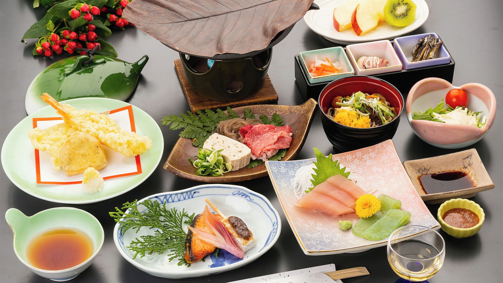Una variedad de platos japoneses dispuestos en una mesa, como sushi, sashimi y tempura.
