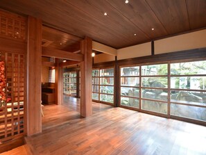 Une pièce spacieuse dotée d’un plancher en bois, de grandes fenêtres et d’un décor intérieur de style japonais traditionnel.