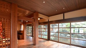 A spacious room with wooden flooring, large windows, and a traditional Japanese-style interior. - Yoshino Ryokan (Hitoyoshi)