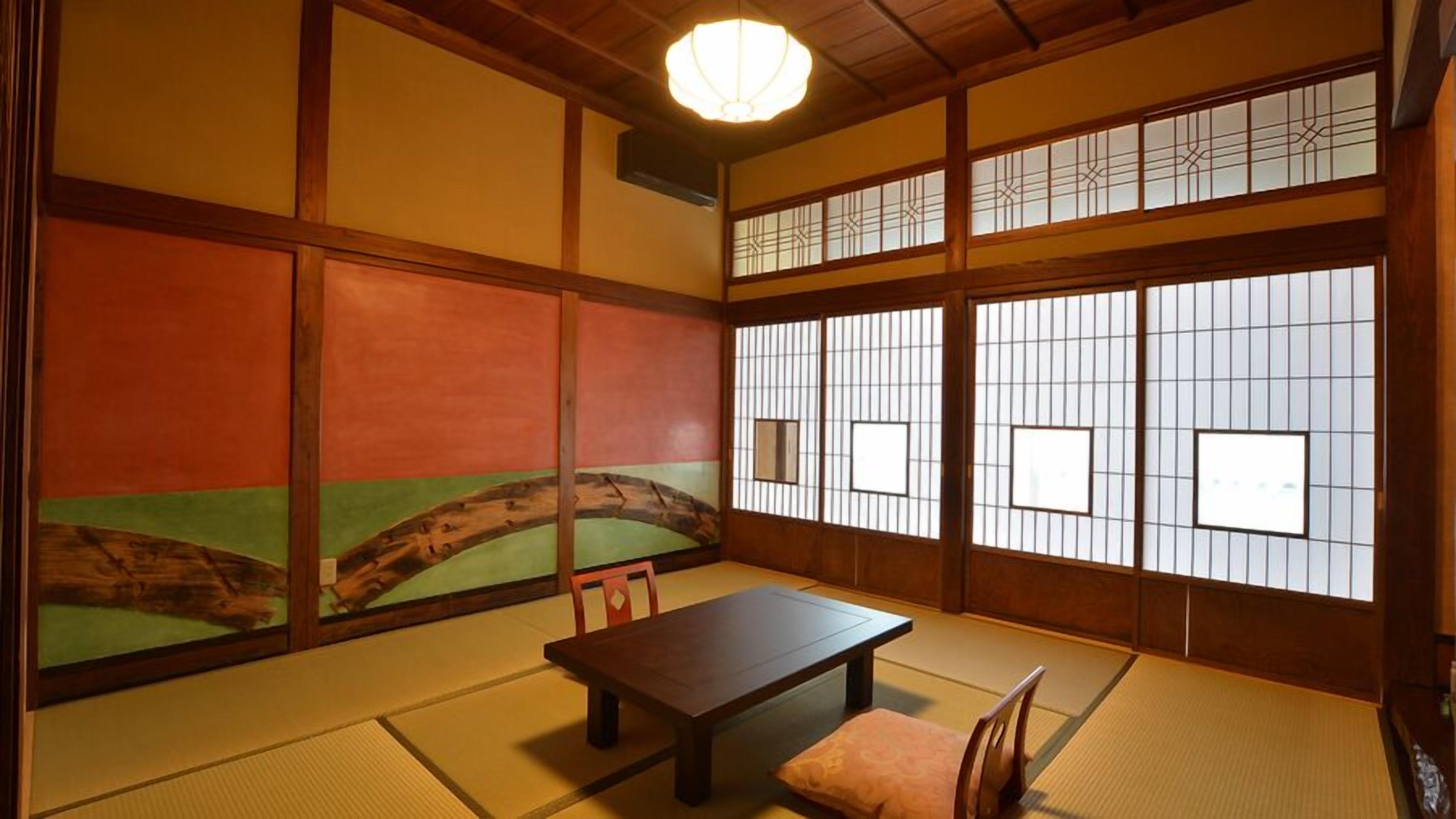 A traditional Japanese room with tatami flooring, a low table, and shoji screens.