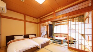 A traditional Japanese room with tatami flooring, a futon bed, sliding doors, and a view of a garden. - Ryotei Saigetsuan (Hirado)