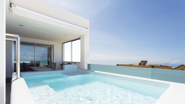 A modern rooftop pool with clear blue water, a glass door entrance, and a view of the ocean. - 🌴☀️ Dream Vacation at Tulio Home Private Pool (Adeje)