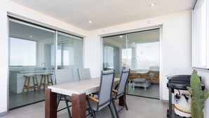 A modern dining area with a glass partition, a wooden table, and chairs. - 🌴☀️ Dream Vacation at Tulio Home Private Pool (Adeje)