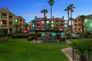 A resort with colorful buildings, a pool area, and palm trees.