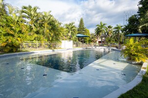 Una piscina al aire libre, sillones reclinables de piscina
