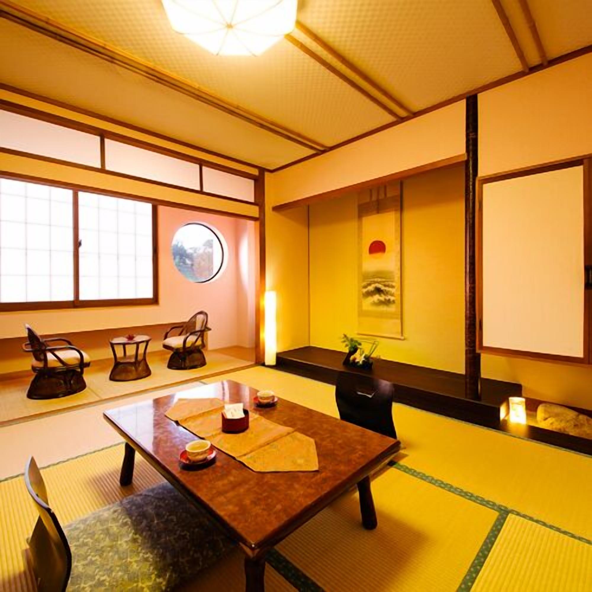 A traditional Japanese room with tatami flooring, a low table with cushions, and a sliding door.