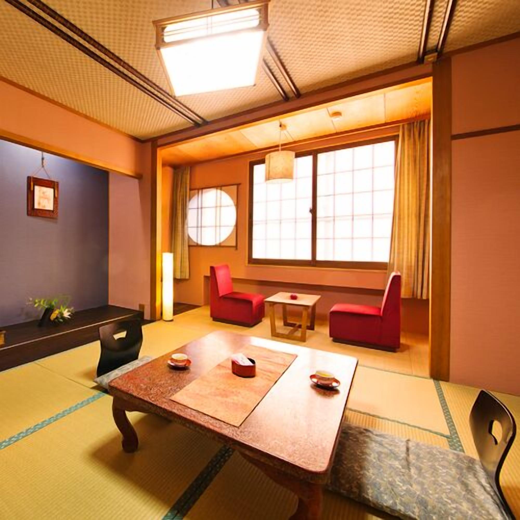 A traditional Japanese-style room with tatami flooring, a low table with cushions, and a sliding door with a view.