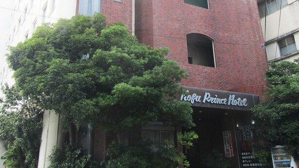 Ein Hotel mit roter Backsteinfassade, zahlreichen Fenstern und einem Schild, das es als Hotel kennzeichnet.