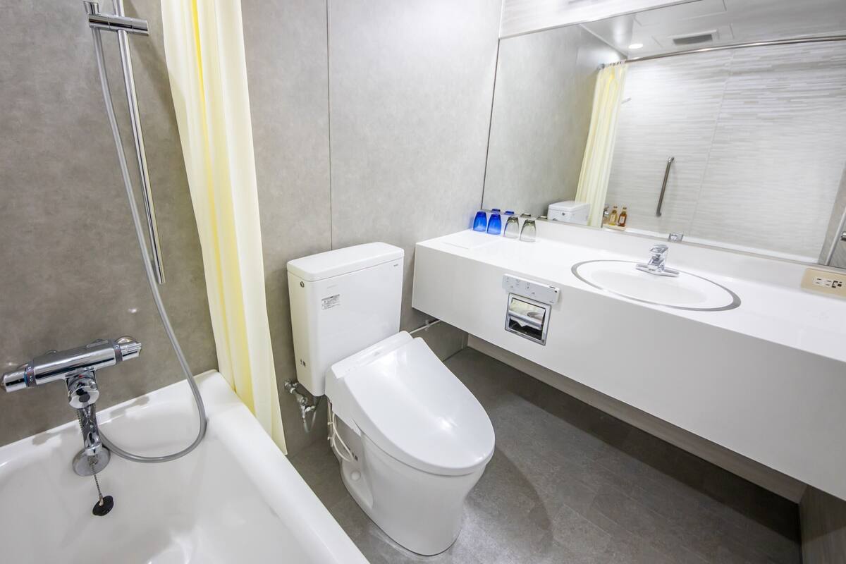 A modern bathroom with a bathtub, toilet, and sink.