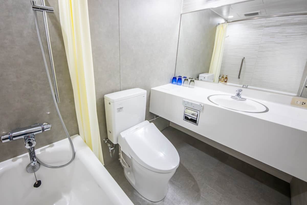 A modern bathroom with a bathtub, toilet, and sink.