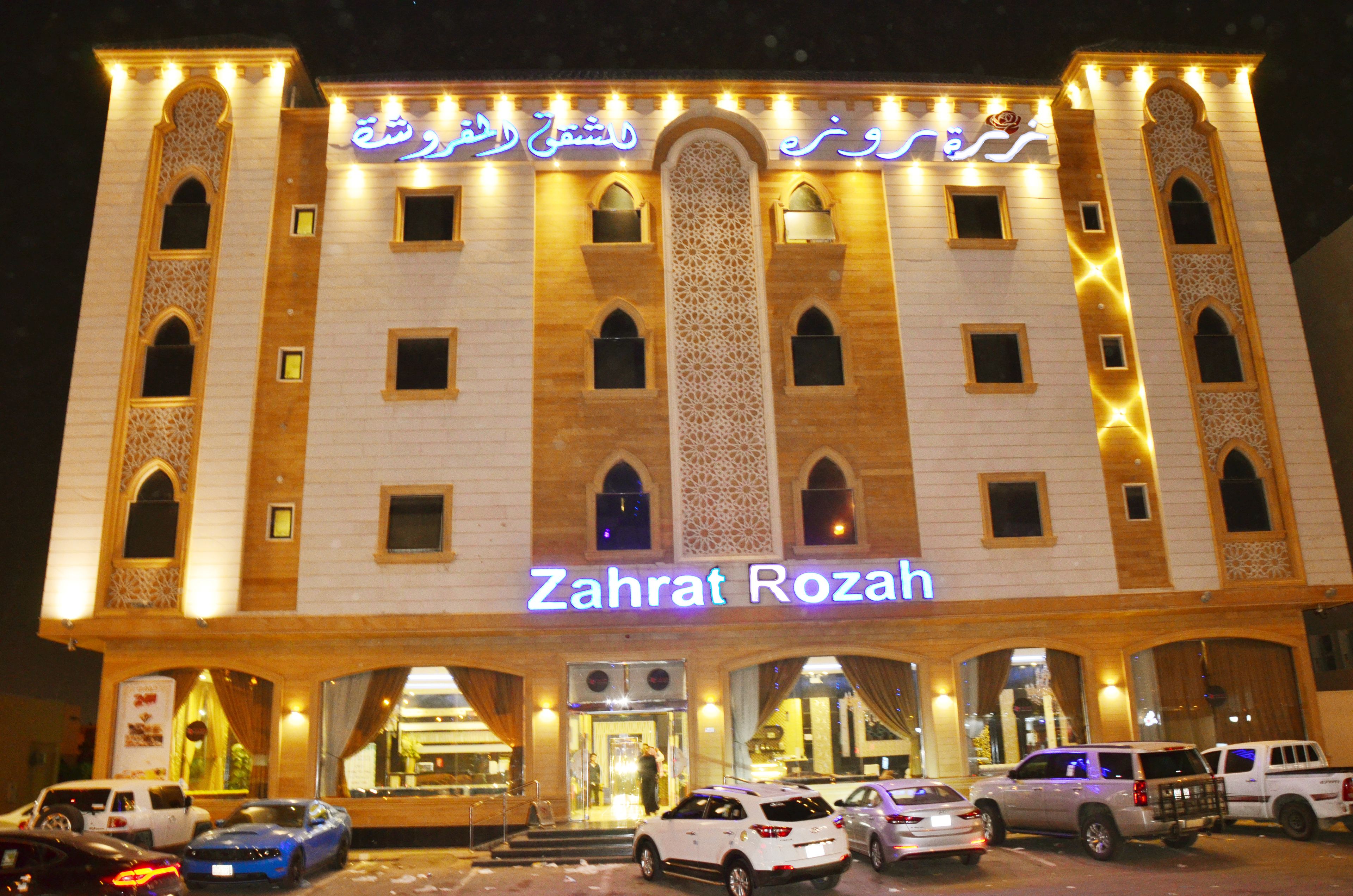 A hotel named "Zahrat Rozah" with a traditional architectural style, featuring multiple windows and a central entrance.