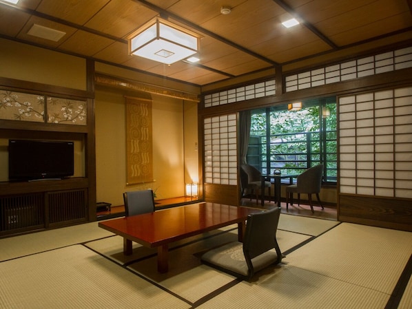A traditional Japanese room with tatami flooring, a low table, and shoji screens.