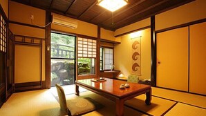 Een traditionele Japanse kamer met tatami vloerbedekking, een lage houten tafel en glijdende deuren.