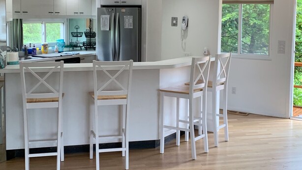 A kitchen with white cabinets, a stainless steel refrigerator, and a sign that reads "BEACH HOUSE". - Ocean Beach/Corneille Est, Fire Island Beach House (Ocean Beach (Cornielle Estates))