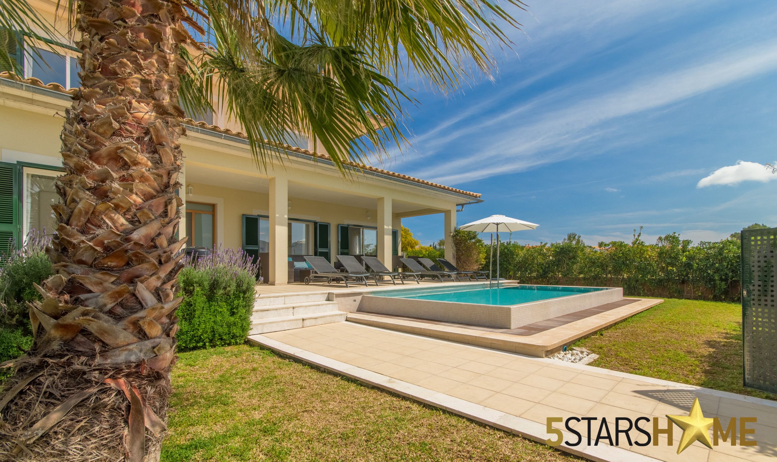 Una casa moderna con piscina, terraza techada y palmeras.