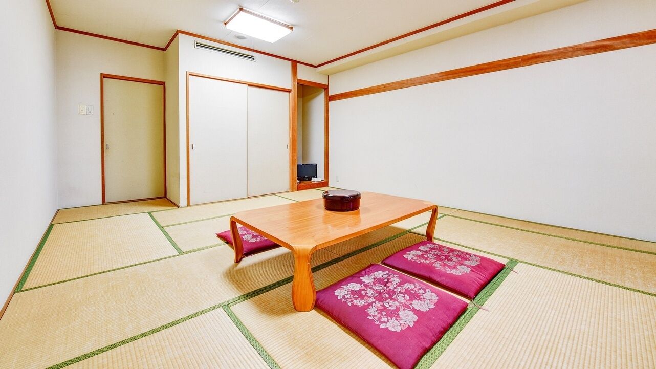 Una habitació tradicional japonesa amb tatamis, una taula de fusta baixa i una porta corredissa.