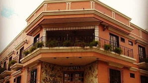 Un hotel con una entrada destacada, una escalera que conduce a la entrada y una bandera en la parte superior.