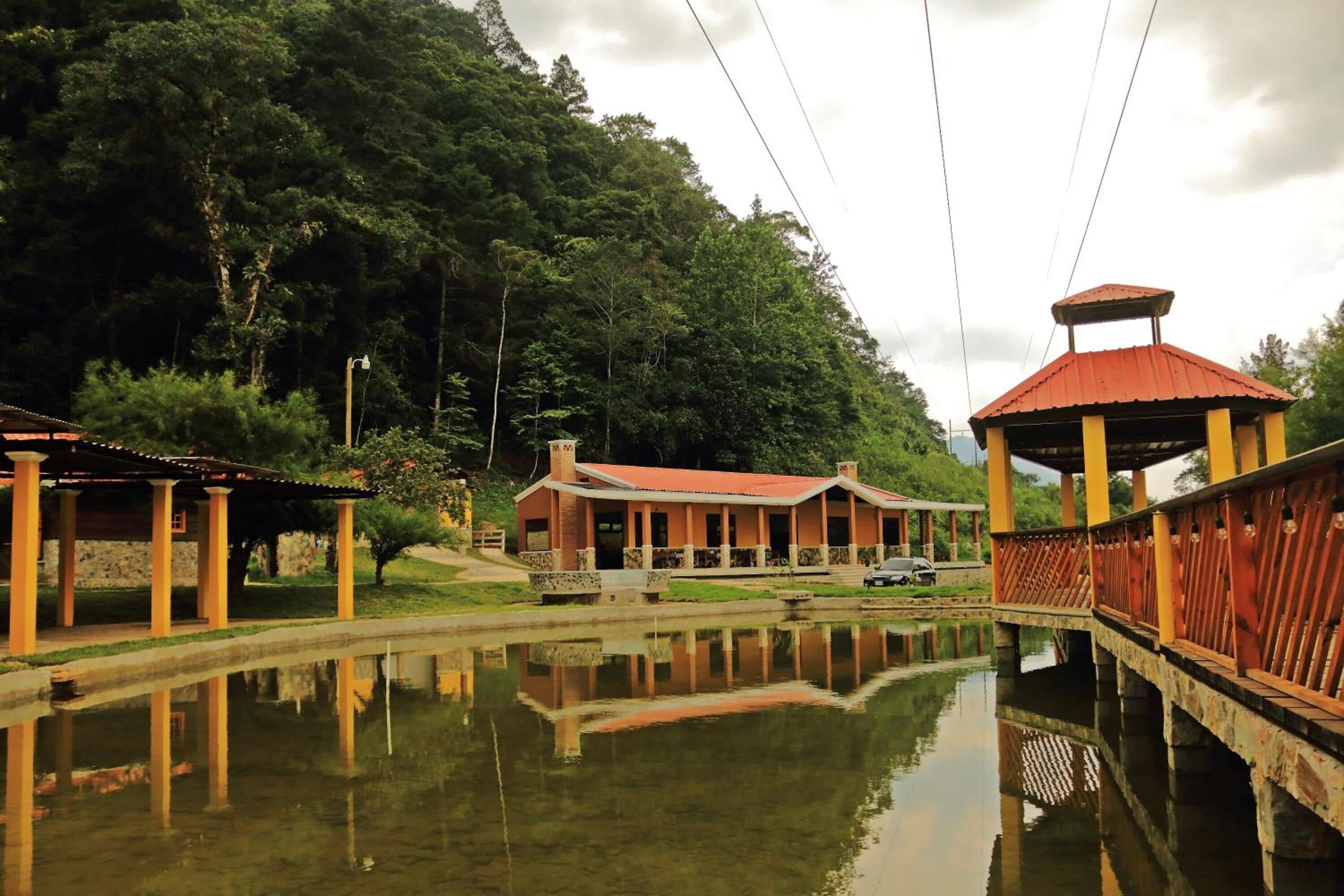 Un entorno tranquilo junto al lago, con un pabellón de madera tradicional y un paseo cubierto sobre el agua.