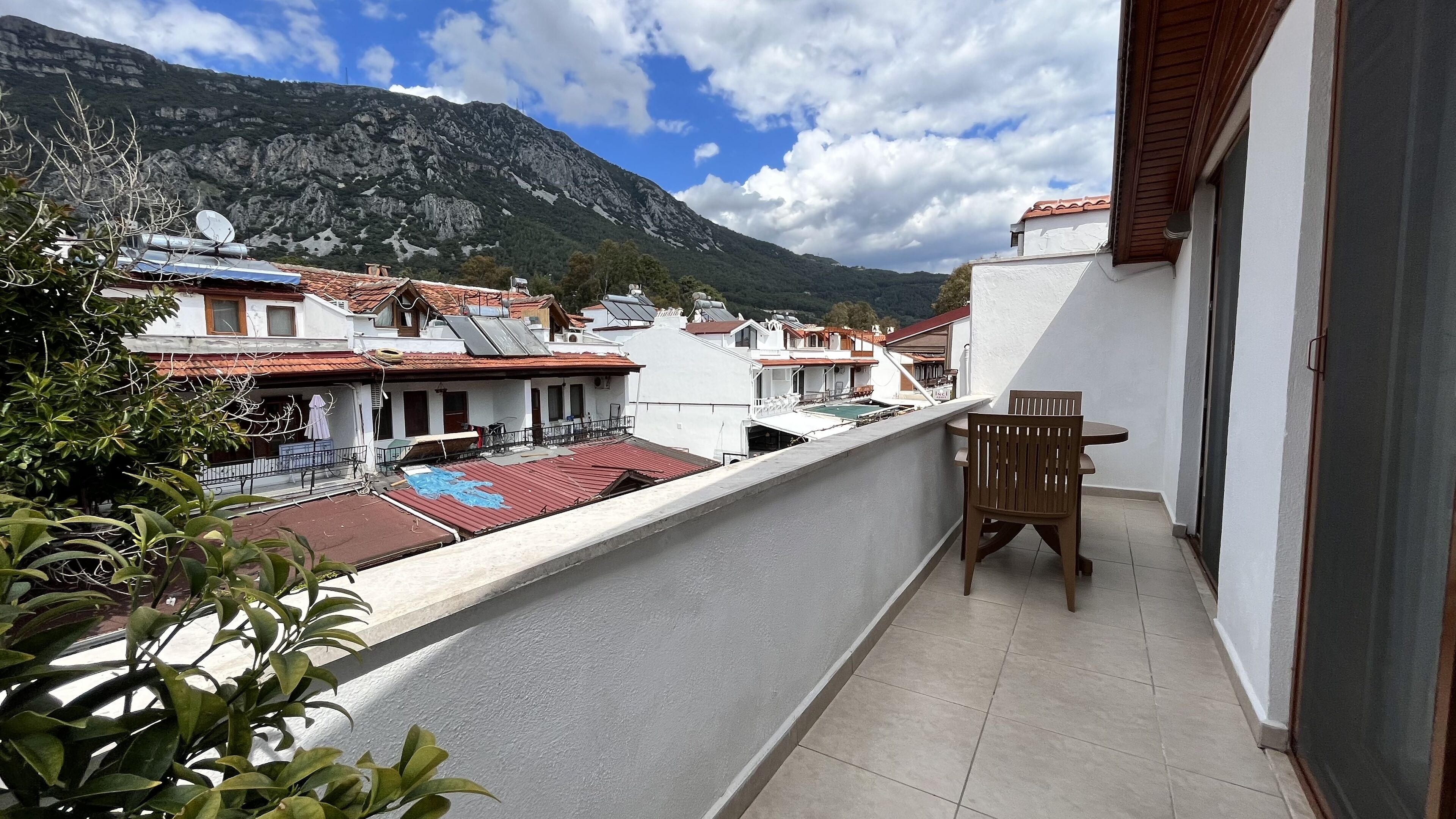 Un balcón con vista a una montaña y edificios residenciales.