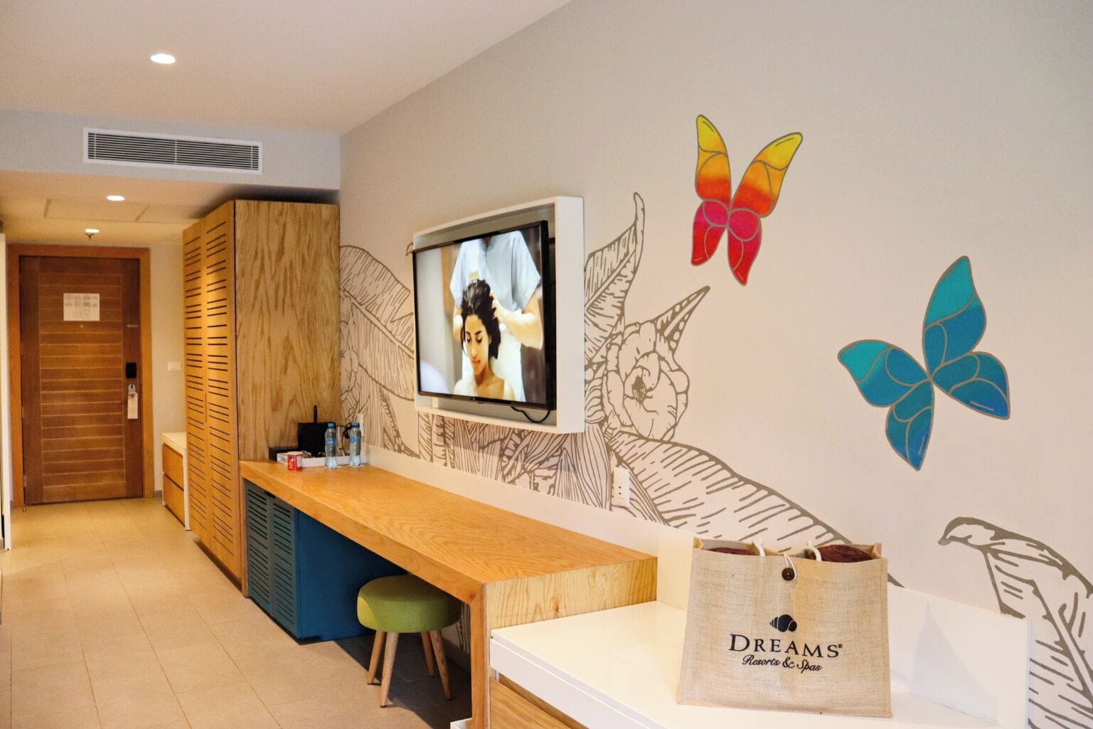 A reception area with a wooden desk, a television, and a wall with butterfly decals.