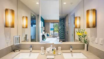 A modern bathroom with two sinks, a large mirror, and decorative wall sconces.