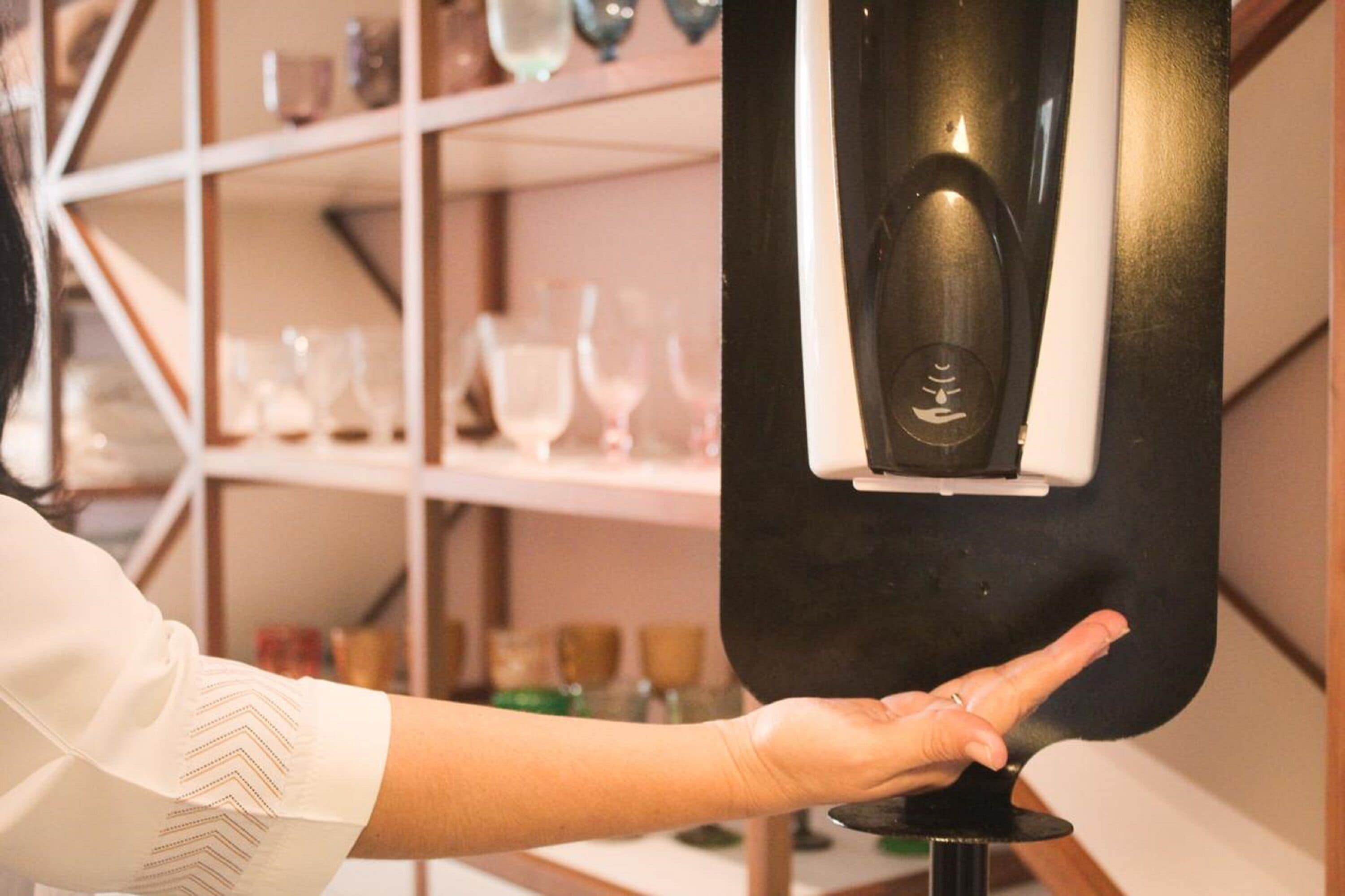 A hand holding a black object with a white base, possibly a piece of equipment or a device.