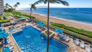 Ein Hotel mit Swimmingpool, Blick auf den Strand und Palmen.