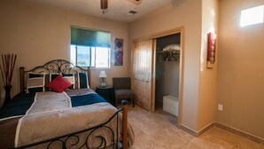A bedroom with a bed, a chair, a nightstand, and a wardrobe. - Separate Private Detached 1 Room Casita with your own entrance (Albuquerque)