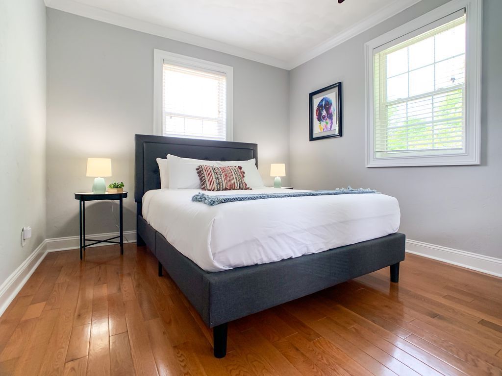 Een slaapkamer met een groot bed, twee nachtkastjes en een raam met zonwering.