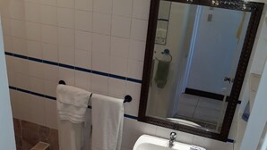 Et badeværelse med en hvid vask, et spejl og et toilet.