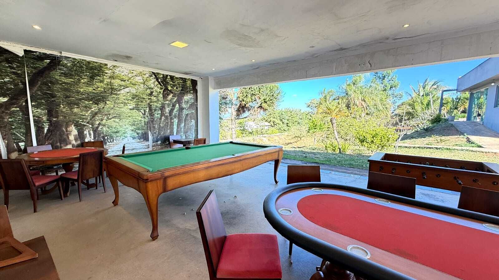 Une table de billard recouverte d’un drap vert, une table de billard recouverte d’un drap rouge et une autre table de billard recouverte d’un drap rouge.