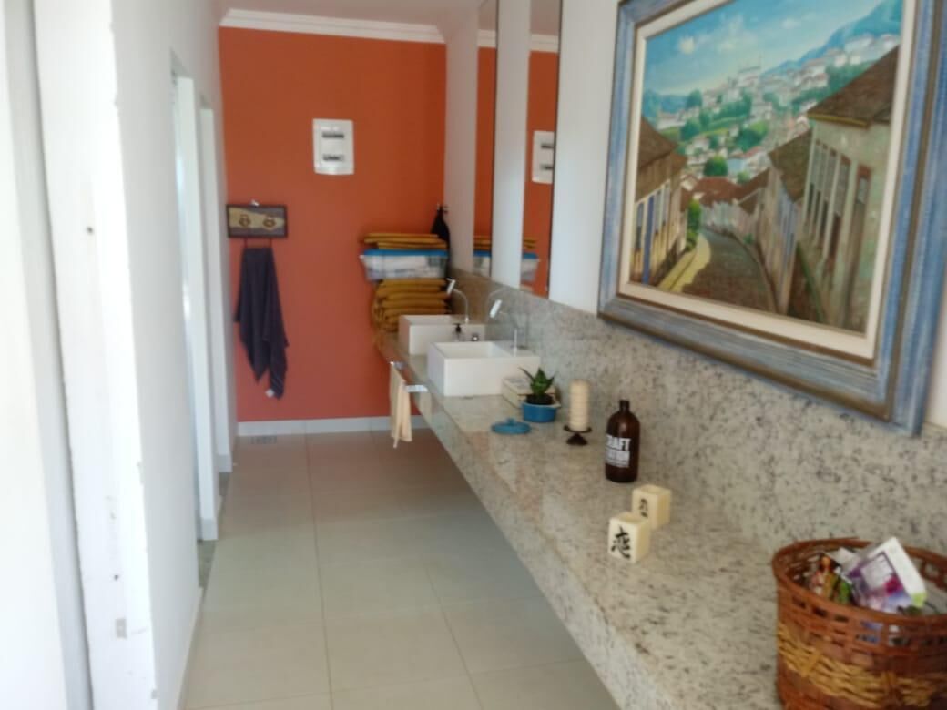 Une cuisine avec un plan de travail en granit, un évier, un tableau et un panier rempli d’objets.