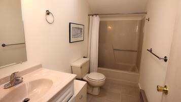 A small, clean bathroom with a sink, toilet, and shower.