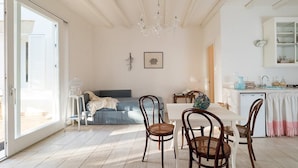 A bright, open-plan living area with a dining table, chairs, and a sofa. - Villa Addolorata - Private villa near Marsala (Marsala)