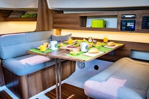 Enjoy a convenient breakfast at the compact kitchenette, featuring a small table and cushioned seating area.