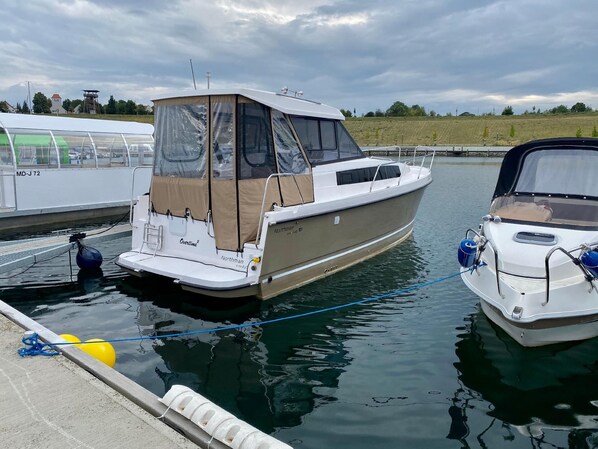 Docked at the marina, this motorboat offers a covered cabin for comfort.