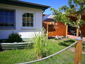 Stroll through the serene garden of RODDEN FARM, surrounded by lush greenery and a tranquil pond.