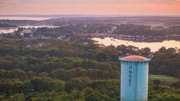 Un château d’eau portant l’inscription « ONSET », avec vue sur un lac et la forêt environnante.