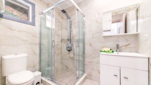 A modern bathroom with a glass-enclosed shower, a toilet, and a vanity with a mirror. - Zakynthos-Summer Sea View (Zakynthos)